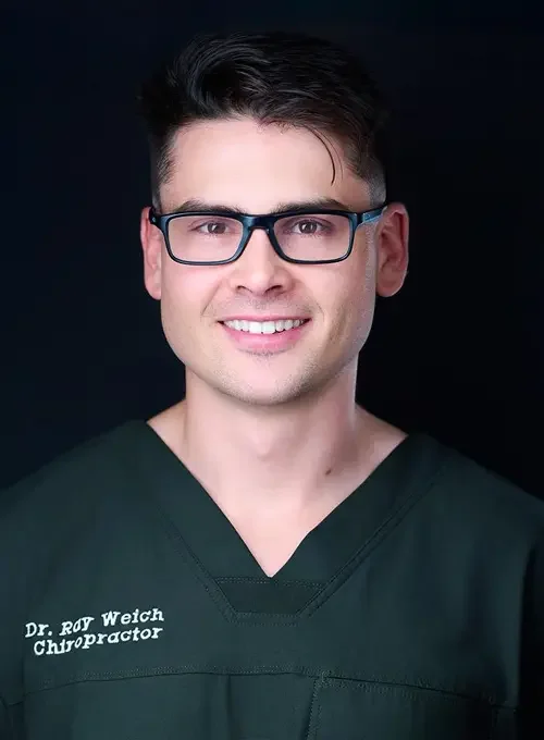 Dr. Raymond Weich wearing dark scrubs and glasses against a black background