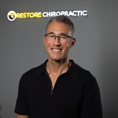 Professional headshot of a man wearing glasses